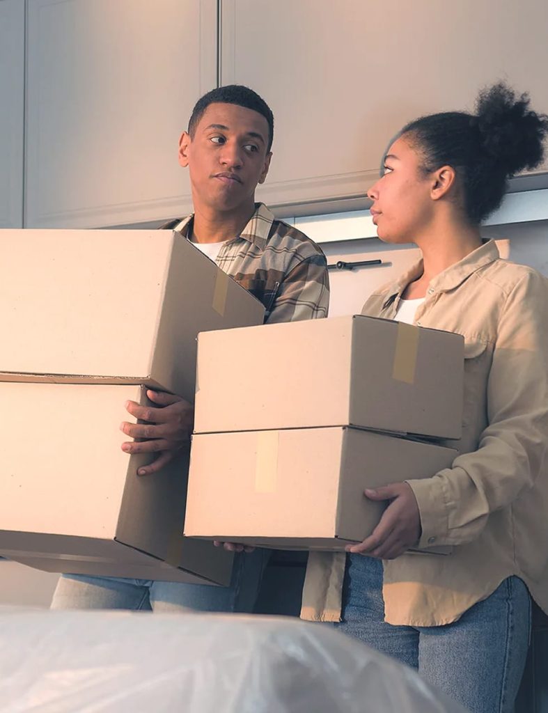 A couple holding moving boxes