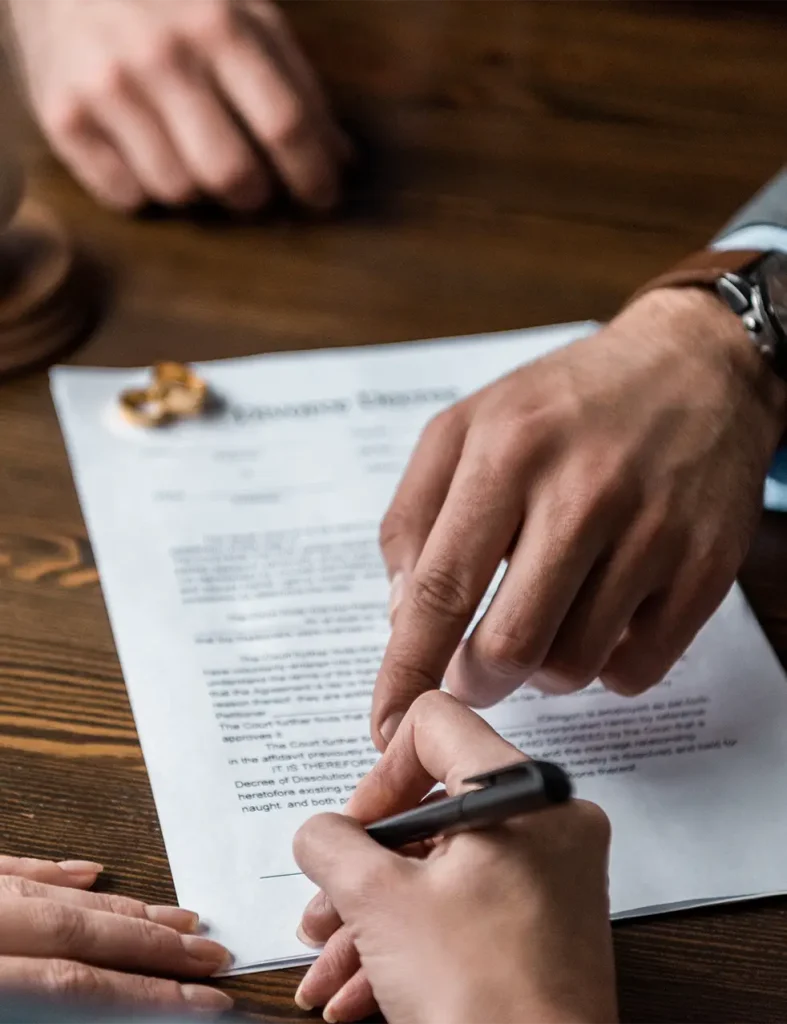 Man signing divorce paperwork with lawyer