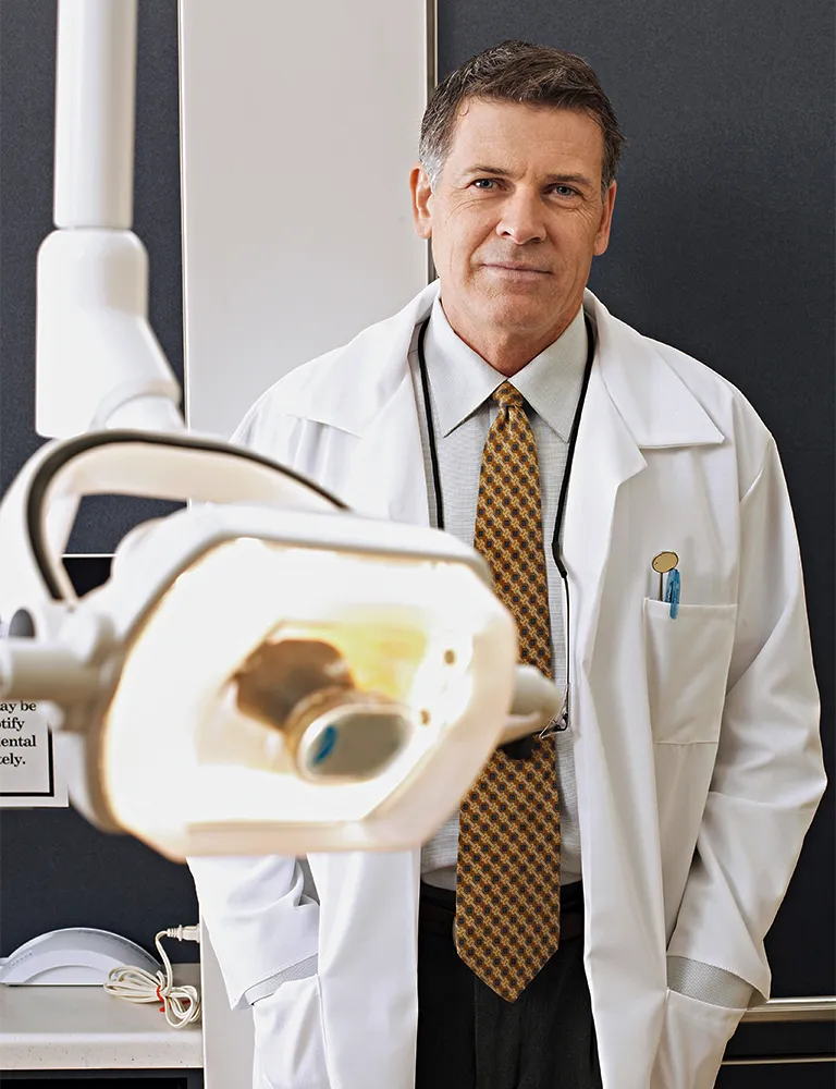 Dentist standing in his clinic, representing professionals with incorporated practices facing divorce